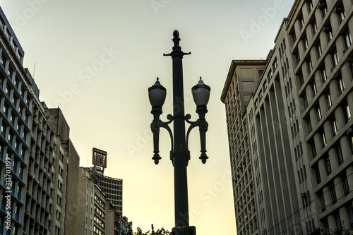 Old vintage street lamp, symbol of the downtown of the city of Sao Paulo, Brazil,  with some buildings.