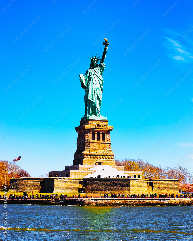 Fototapeta premium Statue on Liberty Island, USA, in Upper New York Bay on Manhattan City Area, America. American architecture building. Metropolis NYC. Cityscape. Hudson, East River NY. Symbol of Freedom.