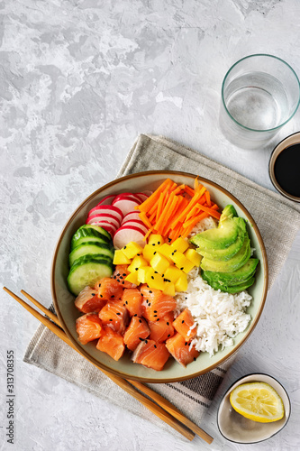 Top view of poke bowl with salmon on light background photo