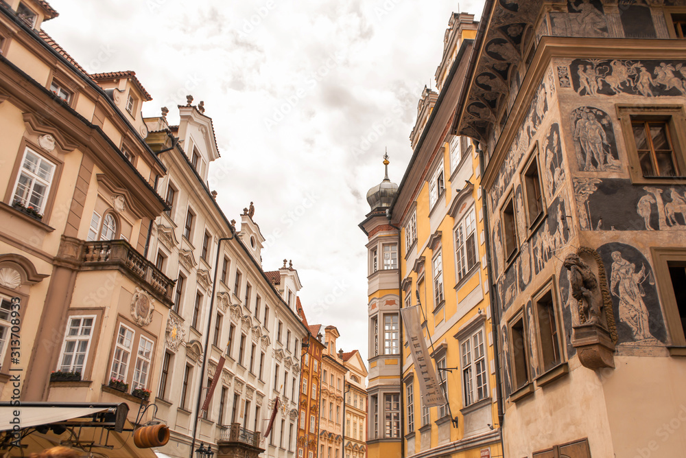 The architecture of the old city of Prague. The ancient building is painted with figures of people.