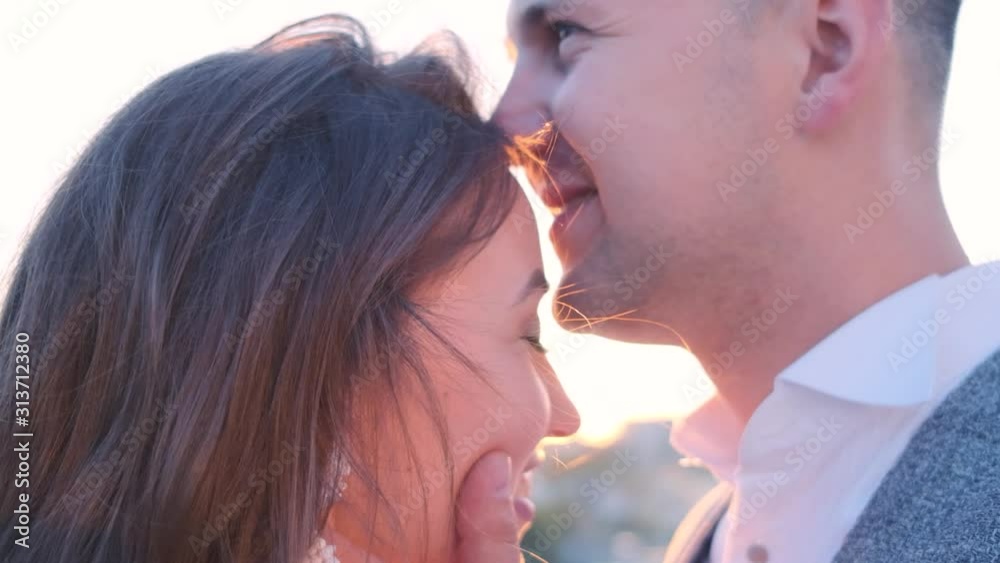 A couple in love at sunset.The lovers are together.The couple kisses laughs and hugs A couple in love at sunset.The lovers are together.The couple kisses laughs and hugs