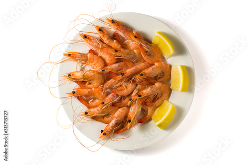 White plate with tasty shrimps with lemon isolated on white background. Top view