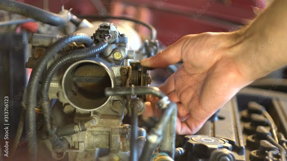 Auto mechanic checks air valve. Detail of a car. Hood space. Close-up. Car service. Parse cars. Spare parts. Car repair. Engine tuning.