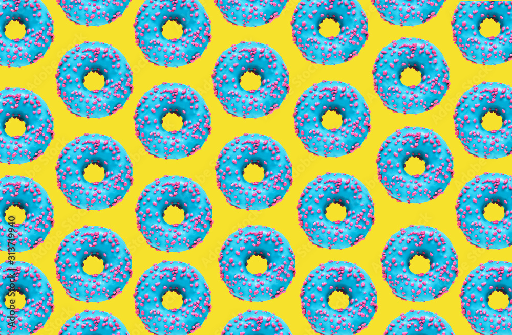 Pattern of a blue donut on a yellow background. Flat lay