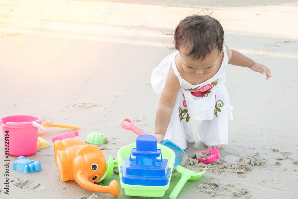 Little girl playing sand alone at the beach. Little girl playing sand alone at the beach.