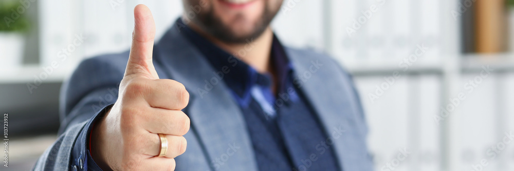 young handsome promising businessman work in office show big finger up