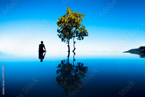 Man sitting at infinity pool overlooking the mountains and in high elevation on a clear day