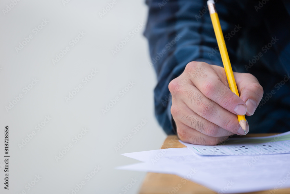 high school,university student study.hands holding pencil writing paper answer sheet.sitting lecture chair taking final exam attending in examination classroom.concept scholarship for education abroad