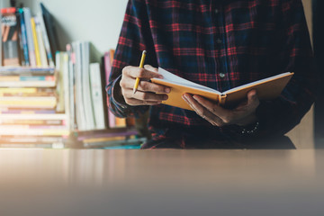 high school,college,university student writing in classroom or library at work space with book stack for knowledge prepare exams scholarship study abroad.research world international education learn