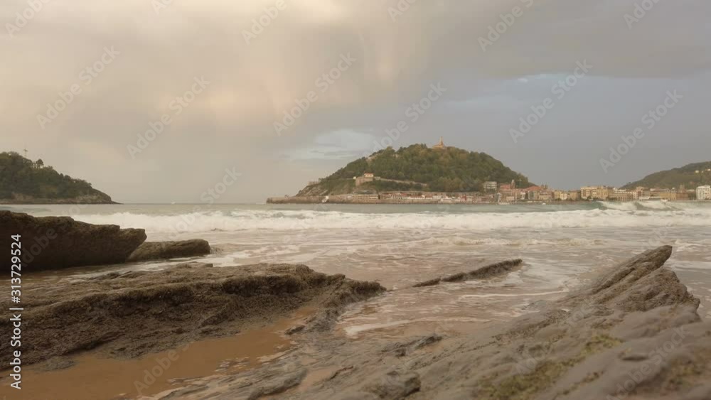 Sunset over the Biscay Donostia San Sebastian Spain. Beach, rocks, sand and golden clouds. 4k and 60fps Sunset over the Biscay Donostia San Sebastian Spain. Beach, rocks, sand and golden clouds. 4k and 60fps