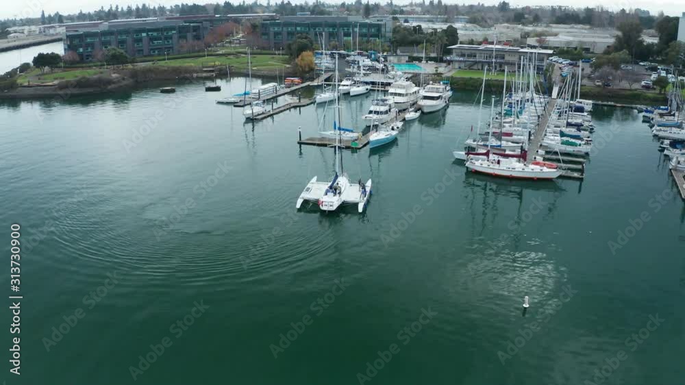 A catamaran boat sailing into the marina to sleep in their slips. A catamaran boat sailing into the marina to sleep in their slips.
