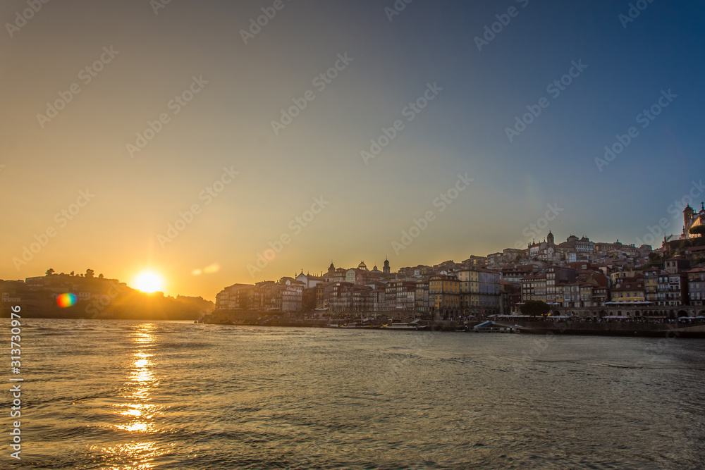 Oporto, Portugal - Douro river and old town ribeira aerial promenade view with colorful houses at sunset