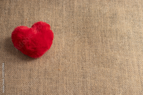 Red fluffy heart shape on gunny sack. Copyspace. Concept of love and relationship and healthcare.
