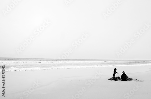 family kids and mum on the beach Black and White silhouette