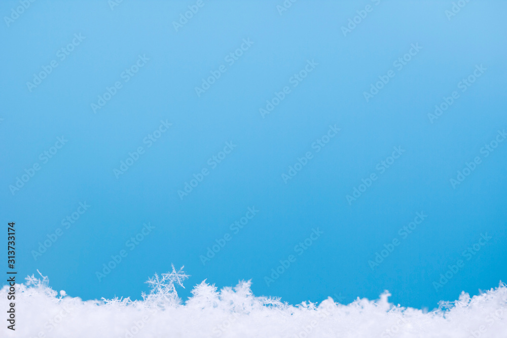 Christmas, New Year and winter background from natural ice snowflakes in close-up in blue tones with copy space for your text. Festive cold frame with borders and real icy crystal snowflakes. Christmas, New Year and winter background from natural ice snowflakes in close-up in blue tones with copy space for your text. Festive cold frame with borders and real icy crystal snowflakes.