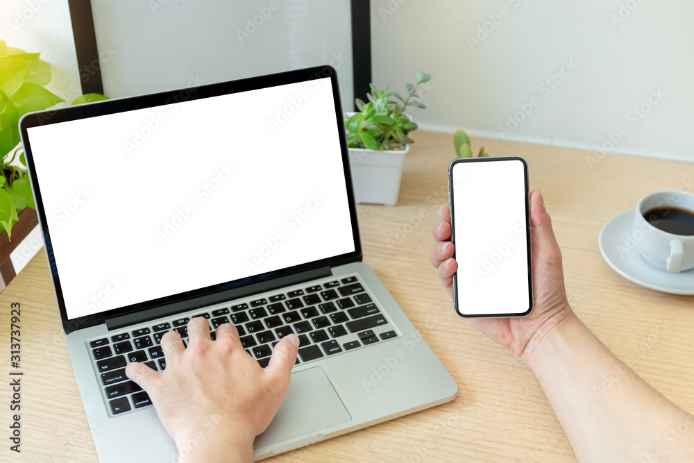mockup image blank screen computer,cell phone with white background for advertising text,hand man using laptop texting mobile contact business search information on desk in office.marketing,design mockup image blank screen computer,cell phone with white background for advertising text,hand man using laptop texting mobile contact business search information on desk in office.marketing,design
