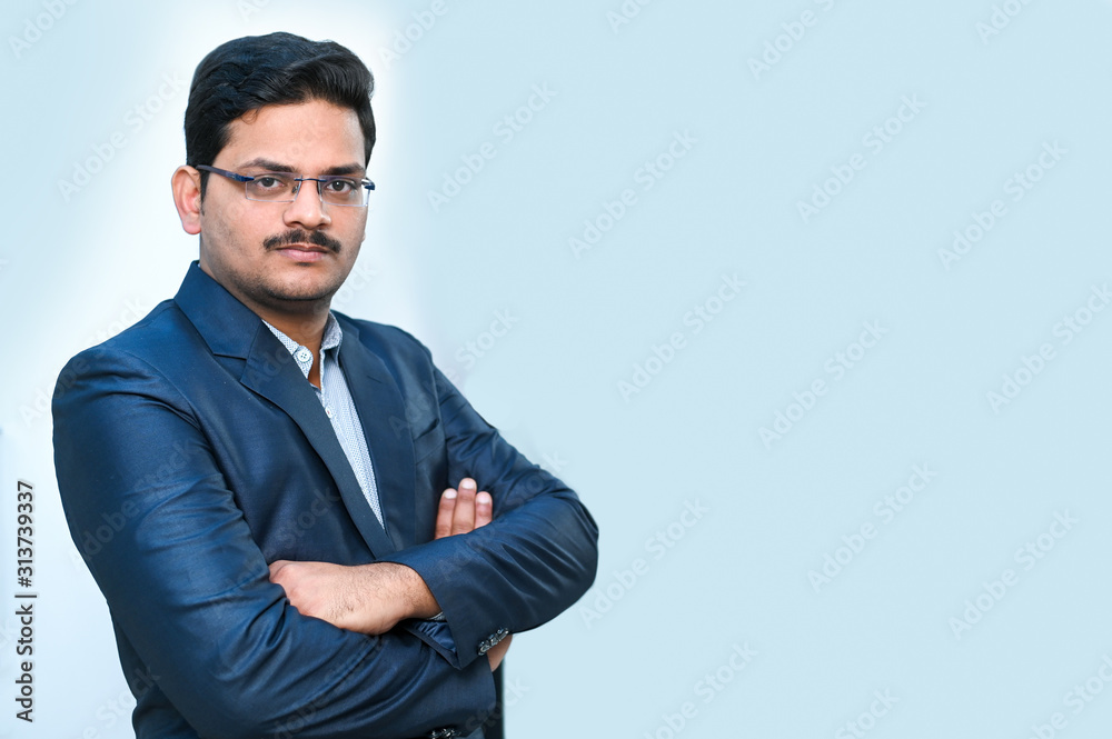 Portrait of an Indian businessman on blue background with extra copy space Portrait of an Indian businessman on blue background with extra copy space