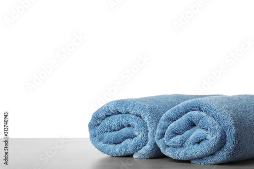 Rolled fresh clean towels for bathroom on table against white background. Space for text