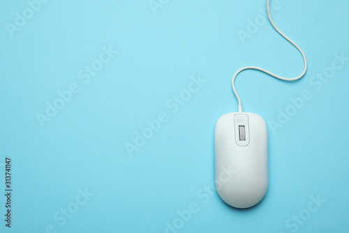 Wired computer mouse on light blue background, top view. Space for text