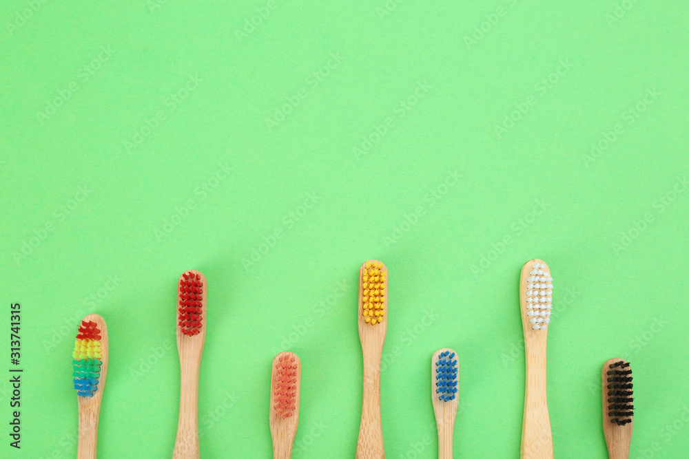 Natural toothbrushes made with bamboo on green background, flat lay. Space for text Natural toothbrushes made with bamboo on green background, flat lay. Space for text