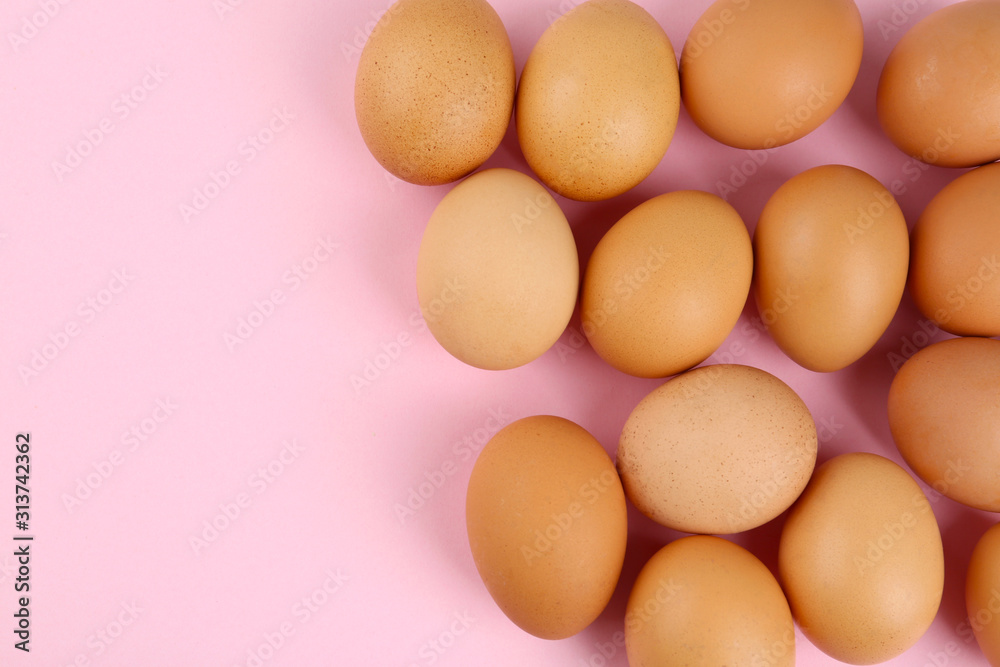 Raw chicken eggs on pink background, flat lay