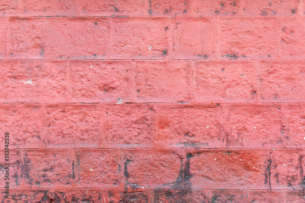 Concrete block wall painted red color of background and texture.