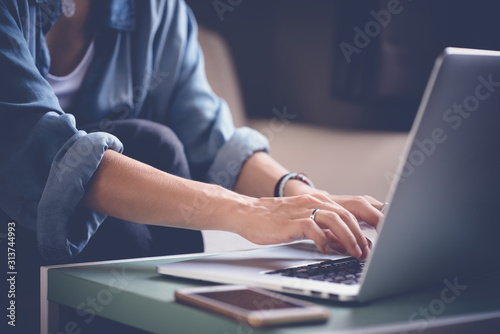 Woman works at a laptop, hands and keyboard close-up. Internet search concept