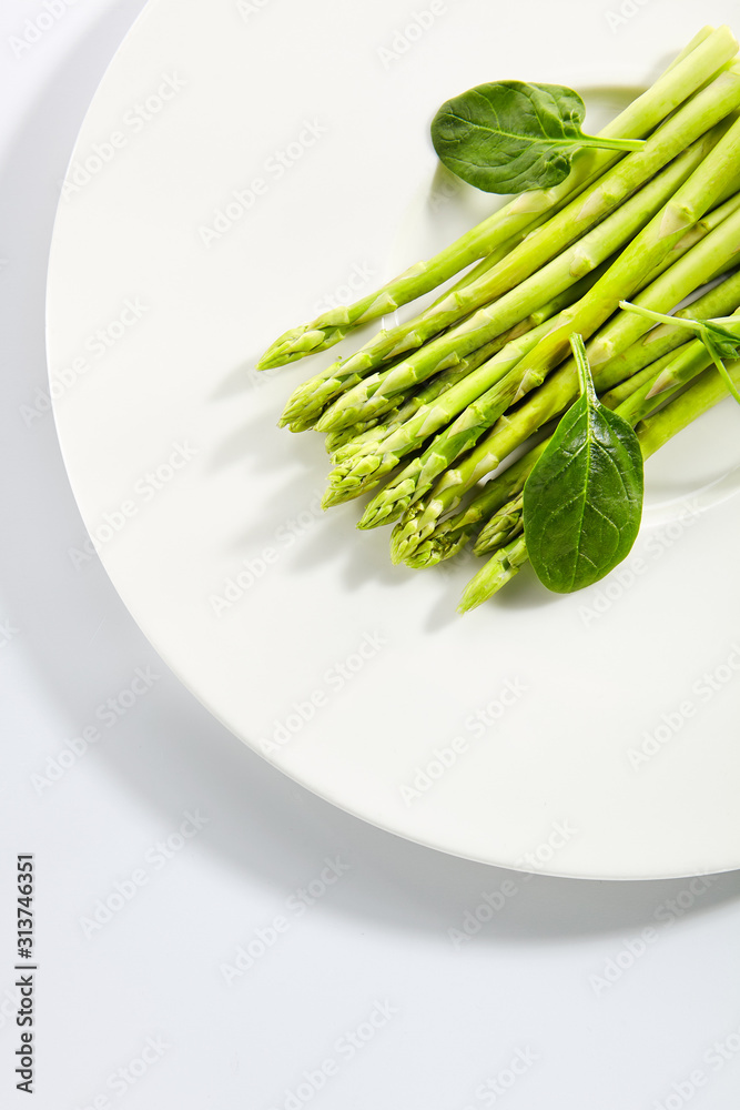 Fresh Young Asparagus Stalks and Green Spinach Leaves Isolated Fresh Young Asparagus Stalks and Green Spinach Leaves Isolated