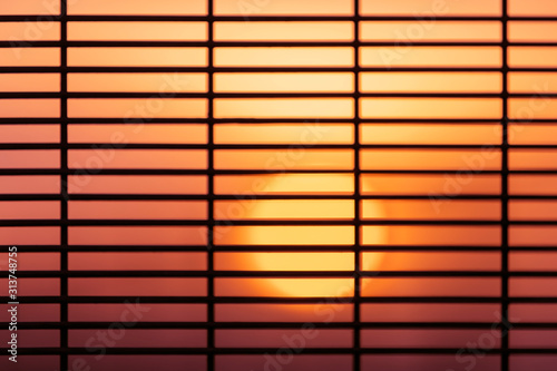 Sunset sky behind grill fence