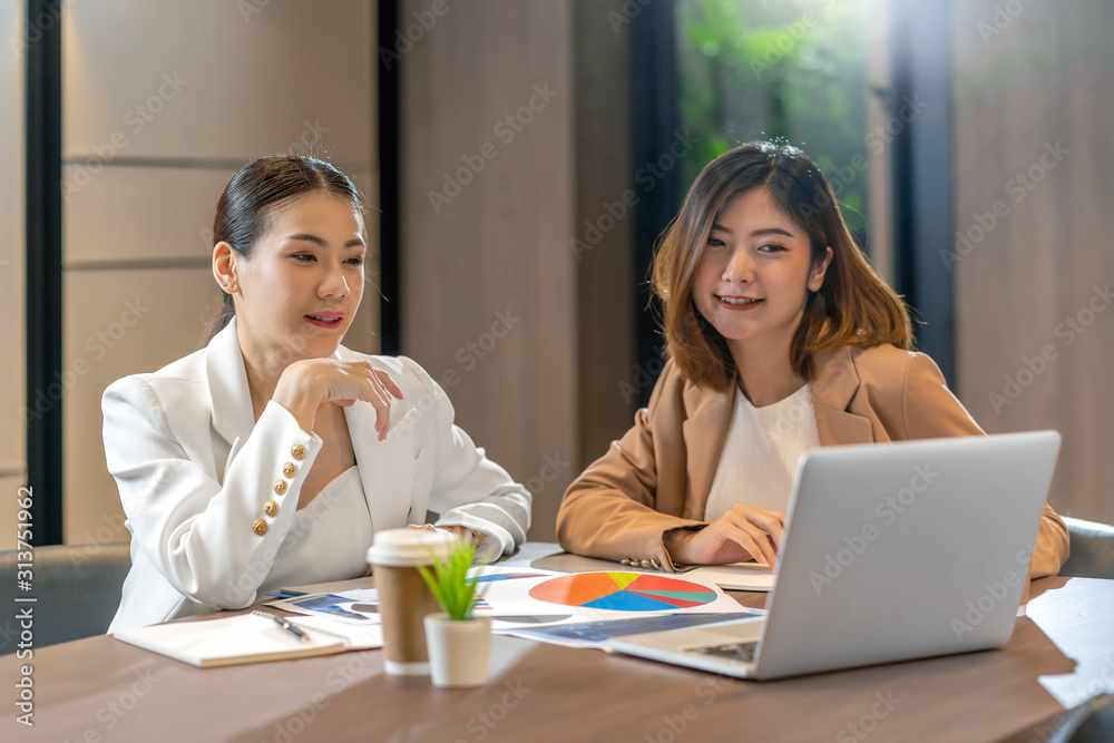 Two asian businesswomen working with the partner business via technology laptop in modern meeting room, office or working space, coffee break, partner and colleague concept Two asian businesswomen working with the partner business via technology laptop in modern meeting room, office or working space, coffee break, partner and colleague concept