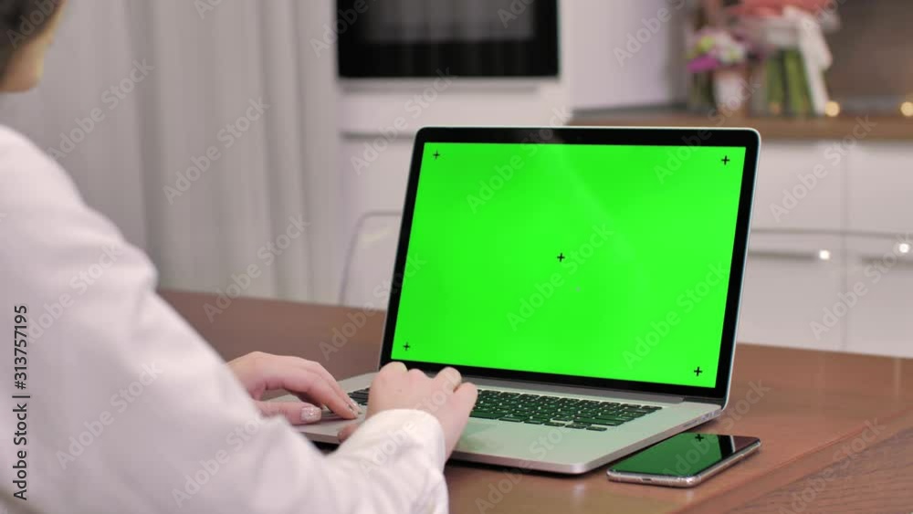 Woman using laptop computer with laptop green screen, 4K shot. Technology, chroma key, template, mockup and entertainment concept.