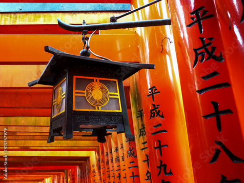 vermilion torii gates and lantern at fushimi inari shrine