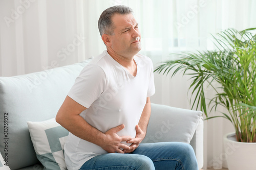 Cuadro en lienzo Mature man suffering from abdominal pain at home