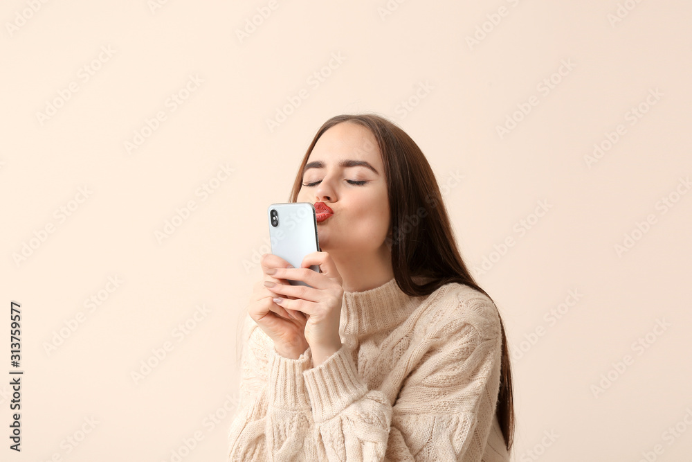 Beautiful young woman with mobile phone on light background Beautiful young woman with mobile phone on light background