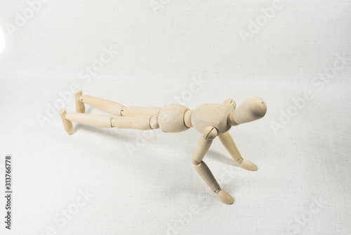 A puppet doing push-ups on a white background.