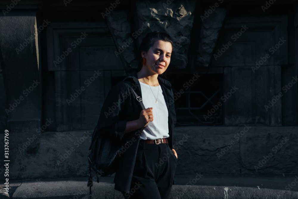 Naklejka premium portrait of young pretty woman at city street sunset light