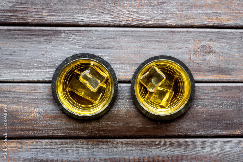 Whiskey with ice. To glasses of strong alcohol drink on dark wooden desk top-down frame copy space Whiskey with ice. To glasses of strong alcohol drink on dark wooden desk top-down frame copy space