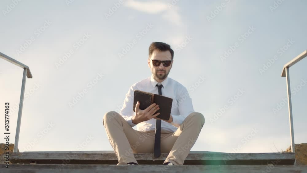 Handsome Peaceful Businessman Relaxing And Enjoying Near River Resting Holding Book.Businessman Take Break Relax After Hard Work In Office And Enjoy Reading Book.Man Sitting And Reading Diary On Pier. Handsome Peaceful Businessman Relaxing And Enjoying Near River Resting Holding Book.Businessman Take Break Relax After Hard Work In Office And Enjoy Reading Book.Man Sitting And Reading Diary On Pier.