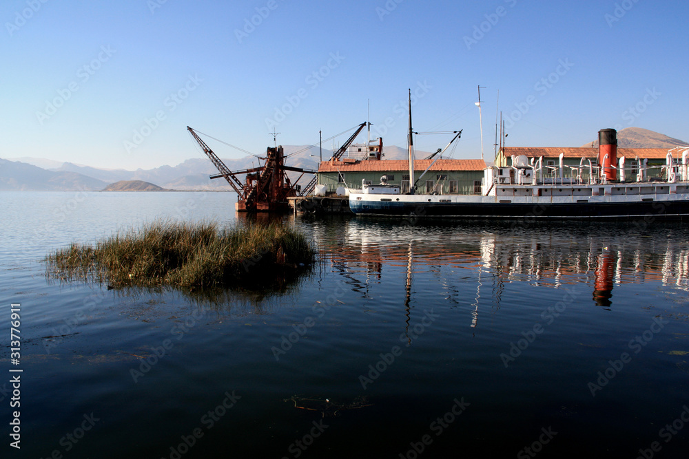 An old baggership, a passenger ship and other nautical equipment resting in the harbor of Puno, Peru