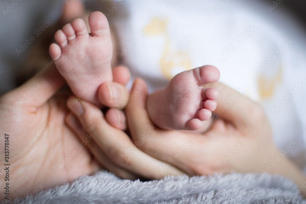 Parents holding baby's feet. Cute baby toes held by loving parent;s hand. Ten Baby toes held lovingly by parent's fingers. Mother's baby. Parents holding baby's feet. Cute baby toes held by loving parent;s hand. Ten Baby toes held lovingly by parent's fingers. Mother's baby.