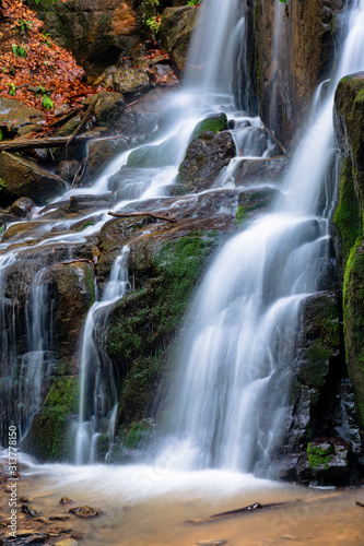 waterfall skakalo in the forests of transcarpathia. rapid water stream runs down the huge boulders. clear water of carpathian nature in springtime. long exposure