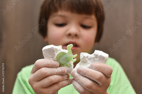 Children having fun with archaeology excavation kit. Boy plays an archaeologist excavated, training for dig fossil