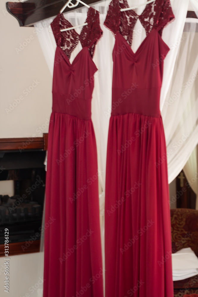 Red bridesmaids dresses hanging on hangers Red bridesmaids dresses hanging on hangers
