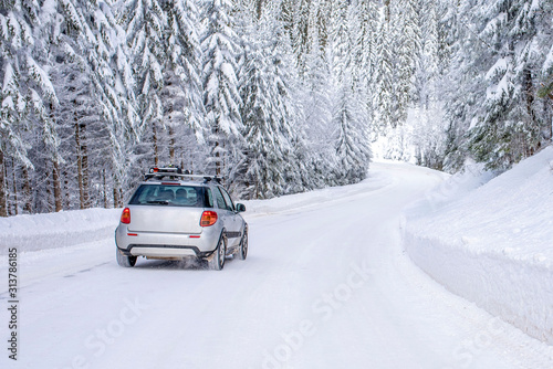 Winter landscape with car on the road and fir trees covered with snow