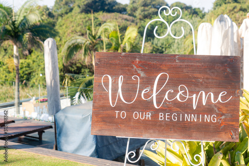 A sign welcoming guests to a wedding reception that reads 