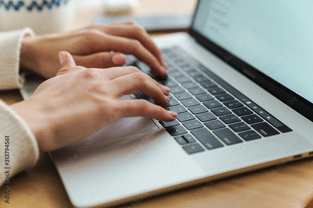 Cropped photo of young caucasian woman typing on laptop Cropped photo of young caucasian woman typing on laptop