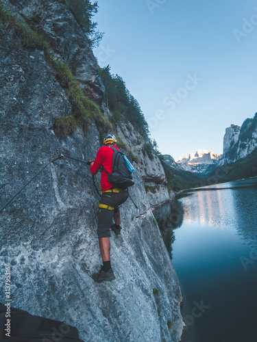 one man climbs on via ferrata in austrian alps