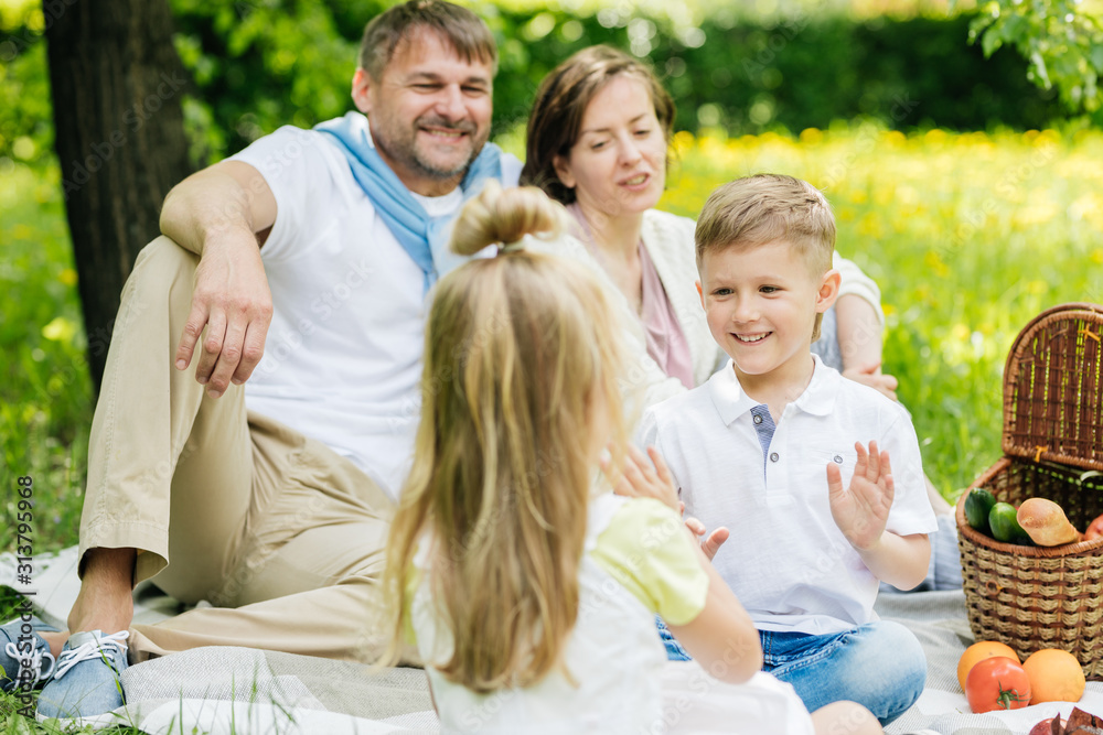 Parents look at their children playing at the picnic. Parents look at their children playing at the picnic.