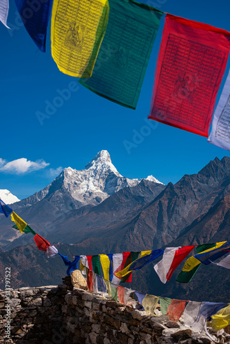 Colourful buddhist tibetan prayer flags (Lungta) with Wonderful view of mountain Ama Dablam in the Himalaya range, eastern Nepal