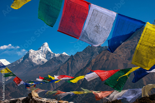 Colourful buddhist tibetan prayer flags (Lungta) with Wonderful view of mountain Ama Dablam in the Himalaya range, eastern Nepal